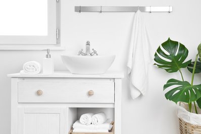 Simple bathroom cabinet with various supplies. Storage and organizing concept